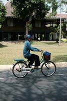 Jakarta, Indonesia - October 2 2023. Elderly Man in Blue Cycling photo