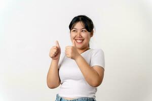 The portrait of beautiful young Asian woman showing thumb up hand sign on white background. Agreement, approval, recommending, like Concept. photo