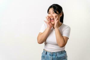 The portrait of beautiful young Asian woman is raising her hand up to her mouth for whisper or shout out gesture. photo
