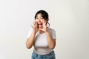 The portrait of beautiful young Asian woman is raising her hand up to her mouth for whisper or shout out gesture. photo