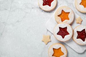 Cooking Christmas background with traditional cookies. Linzer cookies with red and yellow jam photo