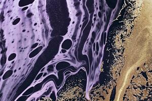 Fluid Art. Metallic gold abstraction and black purple waves. Marble effect background or texture photo