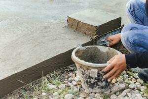 Worker leveling concrete cement floor using trowel. photo