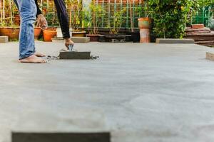 Worker leveling concrete cement floor using trowel. photo