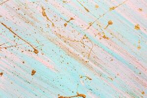 Diagonal pink and blue background with Random gold paint splashes. Place for your design photo