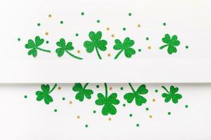 Green glitter shamrocks pattern on white background. Happy St. Patricks Day background photo