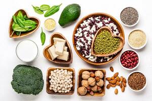 selection of vegetable protein sources. Beans, broccoli, spinach, nuts with bowls photo