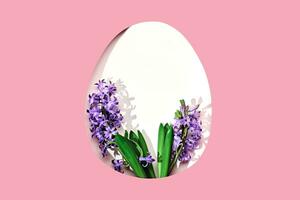 White easter Egg shaped hole with copy space on pink background. Beautiful hyacinths with trendy shadows. Happy easter concept, greeting card photo