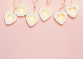 San Valentín día saludo tarjeta. romántico rosado antecedentes con corazón guirnalda. San Valentín día o Boda fiesta decoración foto