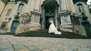 la mariée et jeune marié sur église pas. la mariée et jeune marié posant sur historique église pas. video