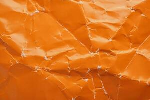 Orange crumpled paper background with folds texture photo