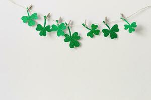 St. Patricks day background with Homemade glitter shamrocks garland photo