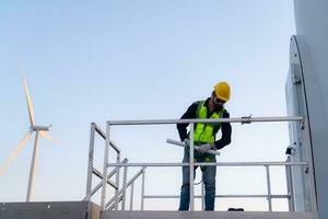 ingeniero a natural energía viento turbina sitio con un misión a escalada arriba a el viento turbina cuchillas a inspeccionar el operación de grande viento turbinas foto