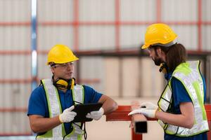 Portrait of two workers using digital tablet stand in front of the red steel structure photo