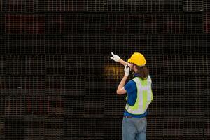 Warehouse worker in hard hats and helmets stand in the warehouse to count and inspect the steel in the warehouse. photo