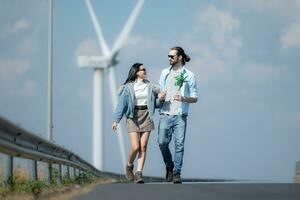 Young couple relaxing by the wind turbine on the lake photo