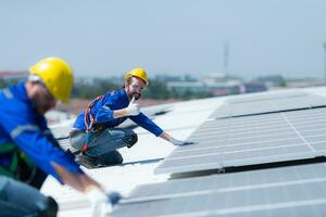 ambos de técnicos es instalando solar paneles en el techo de el almacén a cambio solar energía dentro eléctrico energía para utilizar en fábricas. foto