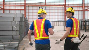 Warehouse workers in hard hats and helmets, Inspect and count steel in the warehouse. photo