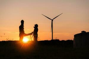 Silhouette of Engineer in charge of wind energy against a background of wind turbines. photo