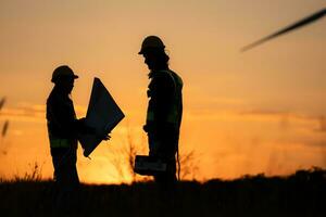 Silhouette of Engineer in charge of wind energy against a background of wind turbines. photo