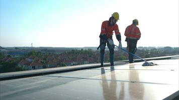 Engineer and technician working on the solar panel on the warehouse roof to inspect the solar panels that have been in operation for some time. photo