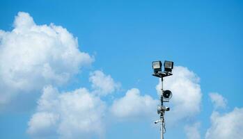 Blue sky background with white clouds and broadcasting speakers with the spotlight photo