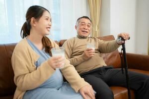 A happy family sits on the sofa in the living room, Father and daughter are pregnant talking to each other. photo