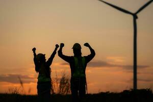 Silhouette of Engineer in charge of wind energy against a background of wind turbines. photo