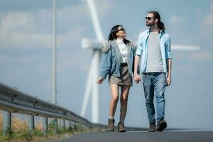 joven Pareja relajante por el viento turbina en el lago foto