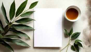 ai generado un blanco papel, un taza de té y un hoja en un blanco antecedentes foto