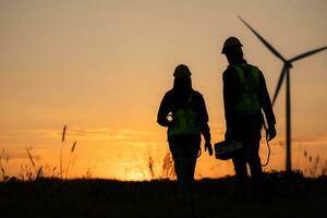 Silhouette of Engineer in charge of wind energy against a background of wind turbines. photo
