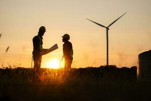 Silhouette of Engineer in charge of wind energy against a background of wind turbines. photo