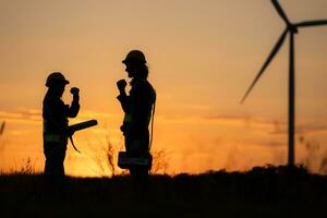 Silhouette of Engineer in charge of wind energy against a background of wind turbines. photo