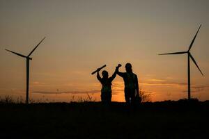 Silhouette of Engineer in charge of wind energy against a background of wind turbines. photo