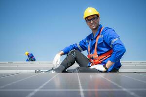 Technician repairing solar panels rest in the scorching sun on a factory roof covered with solar panels to receive solar energy. photo