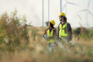 ingeniero y trabajador que se discute en un viento turbina granja con planos foto