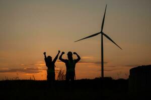 silueta de ingeniero en cargar de viento energía en contra un antecedentes de viento turbinas foto