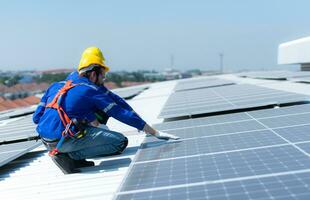 ambos de técnicos es instalando solar paneles en el techo de el almacén a cambio solar energía dentro eléctrico energía para utilizar en fábricas. foto