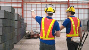 Warehouse workers in hard hats and helmets, Inspect and count steel in the warehouse. photo