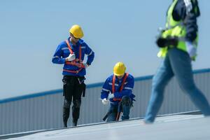 ambos de técnicos es instalando solar paneles en el techo de el almacén a cambio solar energía dentro eléctrico energía para utilizar en fábricas. foto