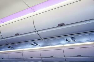 Carry-on luggage in overhead storage compartment on commercial airplane. photo
