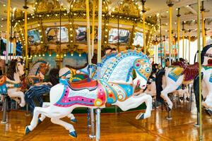 Carousel in amusement park. Horses on a traditional fairground vintage carousel. photo