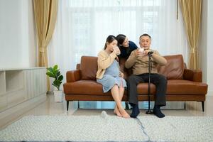 A happy family sits on the sofa in the living room, Father and daughter are pregnant drinking milk and talk to each other. photo