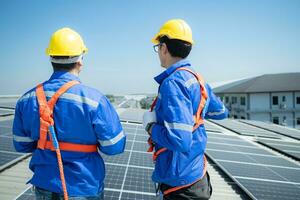 ambos de técnicos es instalando solar paneles en el techo de el almacén a cambio solar energía dentro eléctrico energía para utilizar en fábricas. foto