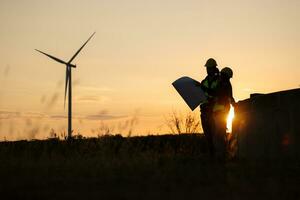 Silhouette of Engineer in charge of wind energy against a background of wind turbines. photo