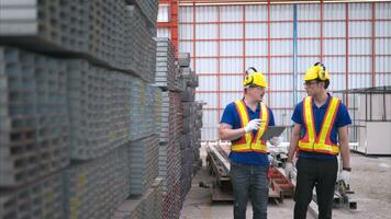 almacén trabajadores en difícil sombreros y cascos, inspeccionar y contar acero en el depósito. foto