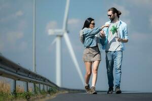 Young couple relaxing by the wind turbine on the lake photo