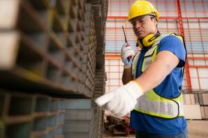 Warehouse worker in hard hats and helmets stand in the warehouse to count and inspect the steel in the warehouse. photo