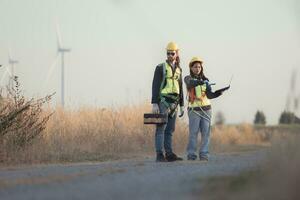 ingeniero y trabajador que se discute en un viento turbina granja con ordenador portátil foto