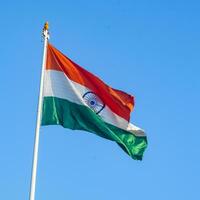 India flag flying high at Connaught Place with pride in blue sky, India flag fluttering, Indian Flag on Independence Day and Republic Day of India, tilt up shot, Waving Indian flag, Har Ghar Tiranga photo